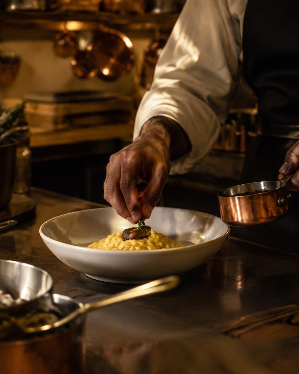 Chef plating risotto (illustrative image)